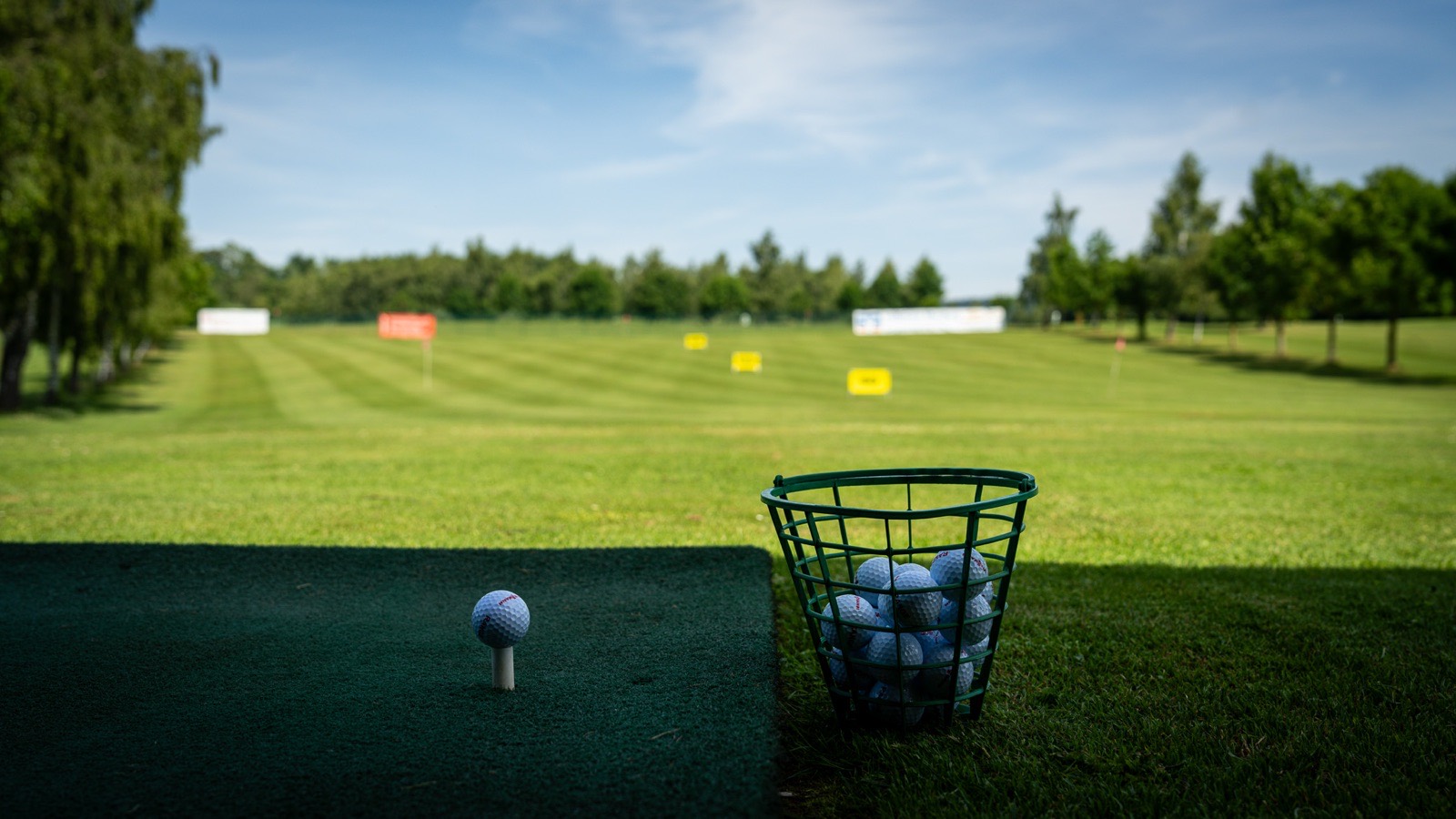 Eisen und Golfball im Moment vor dem Schlag auf der Driving Range
